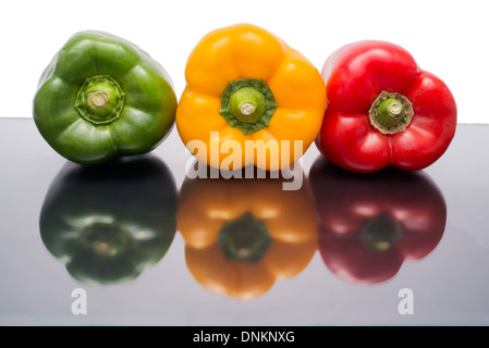 Les poivrons de couleur divers sur une surface réfléchissante Banque D'Images