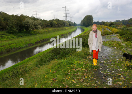Oberhausen, Allemagne, une jeune femme va pour une promenade sous la pluie à l'Emscher Banque D'Images