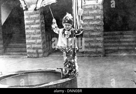 Un garçon vêtu d'un costume du 4 juillet pose pour une photo à Leesburg, en Floride, dans les années 1910 L'image capture l'esprit patriotique et l'architecture locale de l'époque. Banque D'Images