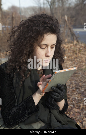 Jeune femme utilise son ipad mini, assis dans le parc de Brooklyn, New York. Banque D'Images