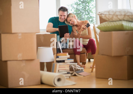 Couple using tablet pc in new home Banque D'Images