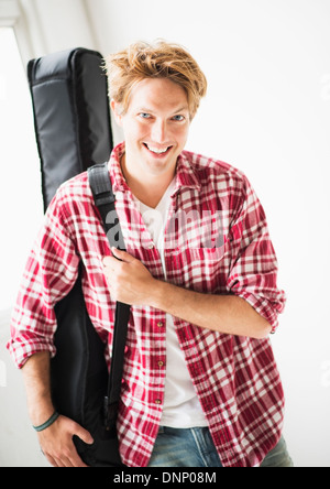 Portrait d'homme portant un sac de guitare Banque D'Images