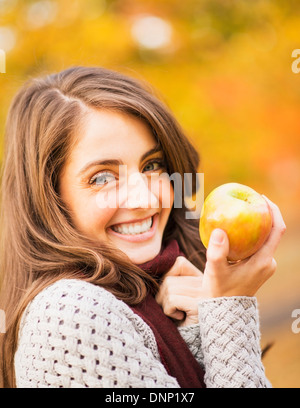 USA, New York State, New York, Portrait of young woman in Central Park holding apple Banque D'Images