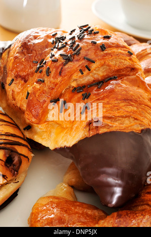 Certains les croissants sur une plaque, sur une table dressée pour le petit déjeuner Banque D'Images