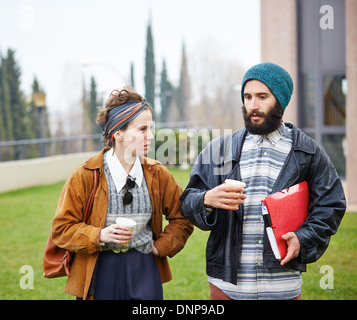 Couple Hipster de parler et de boire du café pour aller au campus universitaire Banque D'Images