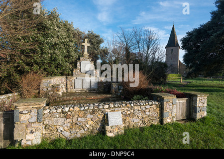 Un mémorial aux morts de la Première et Deuxième Guerres mondiales, avec l'église Holy Trinity en arrière-plan, à Bosham, West Sussex, Royaume-Uni Banque D'Images