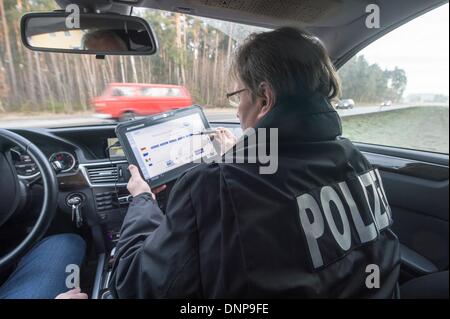 Schwandorf, Allemagne. 06Th Jan, 2014. Un officier de la soi-disant Schleierfahndung, contrôle des personnes sans méfiance, les chèques d'une personne près de Schwandorf, Allemagne, 03 janvier 2014. Le ministre de l'Intérieur bavarois des plans pour lutter contre la criminalité transfrontalière avec beaucoup plus de contrôle et une plus grande présence policière. Photo : ARMIN WEIGEL/dpa/Alamy Live News Banque D'Images