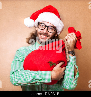 Guy holding un cadeau et émotionnellement Joyeux Noël Banque D'Images