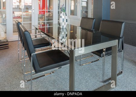 Magasin de meubles modernes d'exposition avec table en verre et chaises Banque D'Images