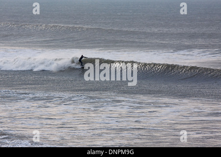 Un surfeur à Woolacombe Bay, North Devon UK. Le surf au large de cette côte est populaire toute l'année Banque D'Images