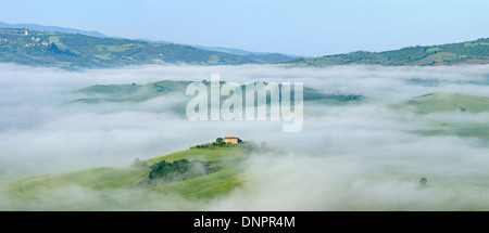 Paysage typique de la Toscane avec ferme en matin de brouillard près de Pienza. Pienza, Sienne, Toscane, Toscana, Italie. Banque D'Images