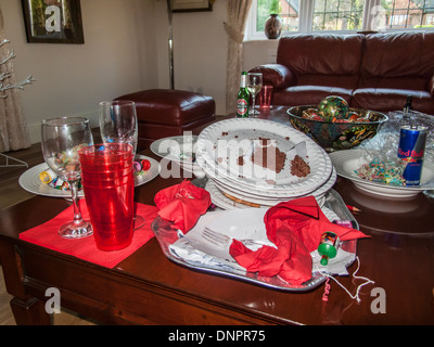 Gâchis après une saison festive party - dirty assiettes en papier, verres en plastique, serviettes, verres vides jetés, verre bouteille et peut Banque D'Images