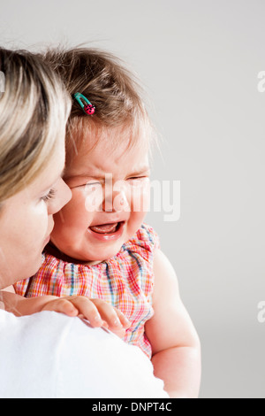 Portrait de Mère holding Crying Baby Girl, Studio Shot Banque D'Images