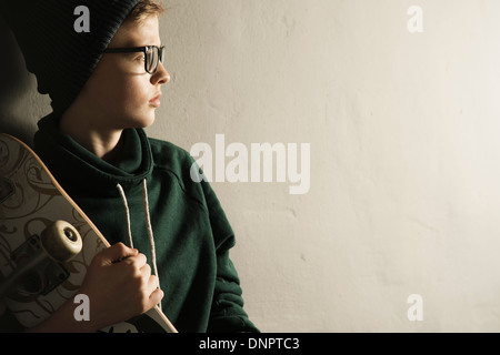 Portrait of Boy with Skateboard, Studio Shot Banque D'Images