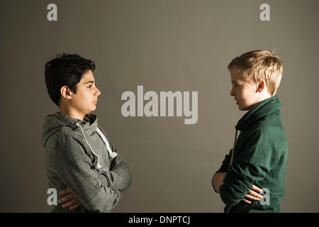 Adolescents avec les bras croisés se regarder, Studio Shot Banque D'Images