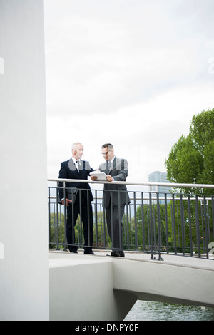 Les hommes d'âge mûr se tenant sur le pont extérieur de parler, Mannheim, Allemagne Banque D'Images
