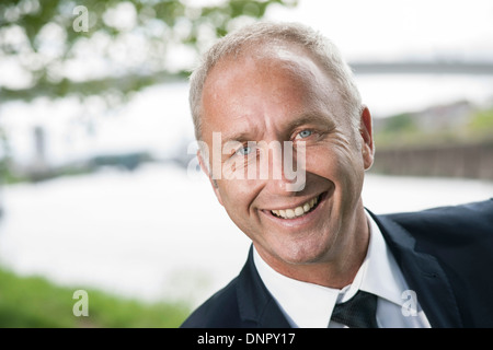 Close-up portrait of mature businessman smiling at camera Banque D'Images