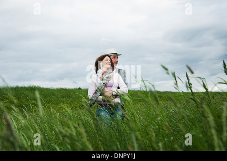 Mature couple standing in field of grass, enlacés, Allemagne Banque D'Images