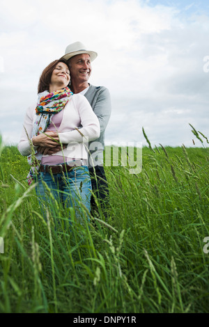 Portrait of mature couple standing in field of grass, enlacés, Allemagne Banque D'Images