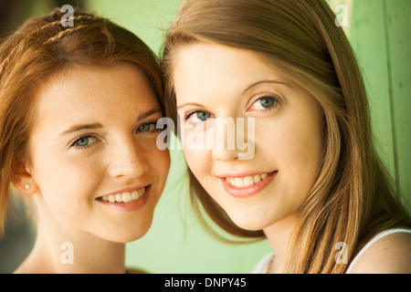 Close-up portrait of young women outdoors, smiling at camera Banque D'Images