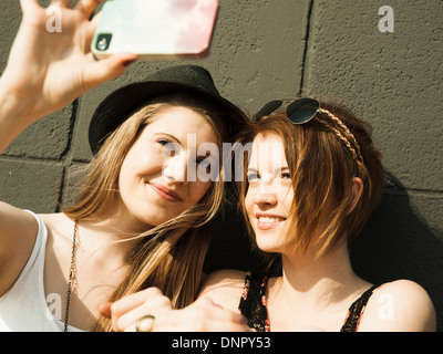 Close-up of young women taking photo d'eux-mêmes avec smart phone Banque D'Images