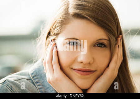 Close-up portrait of young woman outdoors, smiling at camera Banque D'Images