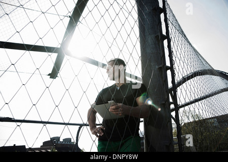 Couple sur le terrain extérieur de basket-ball holding tablet computer, Allemagne Banque D'Images