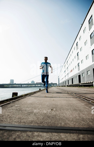 Man jogging en face de l'entrepôt, Mannheim, Allemagne Banque D'Images