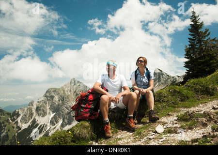 Young couple sitting on grass, randonnées en montagne, vallée de Tannheim, Autriche Banque D'Images