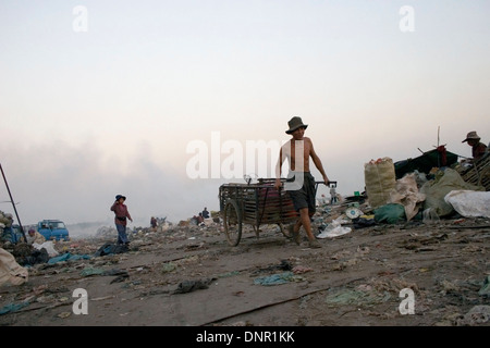Un travailleur est tirant une charrette utilisée pour les matières toxiques à la décharge de Stung Meanchey à Phnom Penh, Cambodge. Banque D'Images