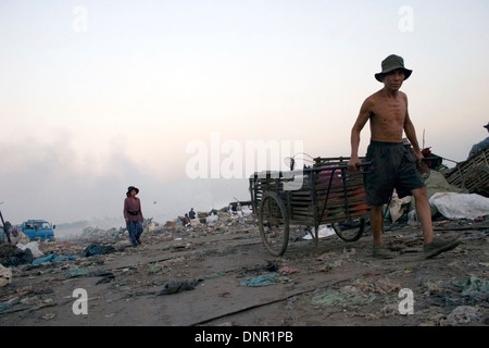 Un travailleur est tirant une charrette utilisée pour les matières toxiques à la décharge de Stung Meanchey à Phnom Penh, Cambodge. Banque D'Images