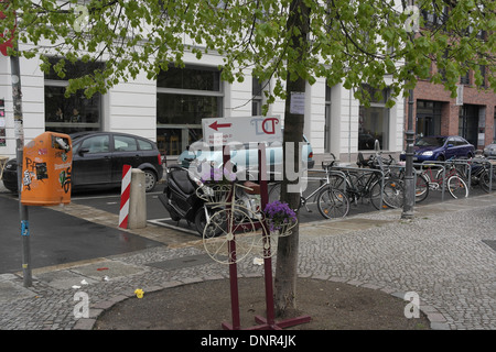 Voir les vélos enchaînés, Mozzarella Bar windows, petit Penny-Farthing avec fleurs violettes par arbre de la chaussée, Joachimstrasse, Berlin Banque D'Images