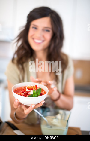 Jolie femme la préparation des fruits dans le bol mélangeur Banque D'Images