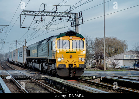 Train de marchandises passant sur le passage à niveau. Banque D'Images