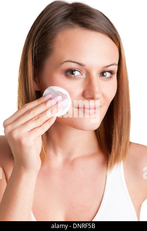 Woman make-up avec un disque de coton devant un miroir, isolé en blanc Banque D'Images