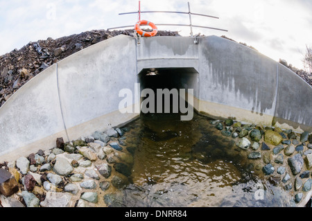 La réorientation d'un ponceau en béton petit ruisseau sous une nouvelle route Banque D'Images