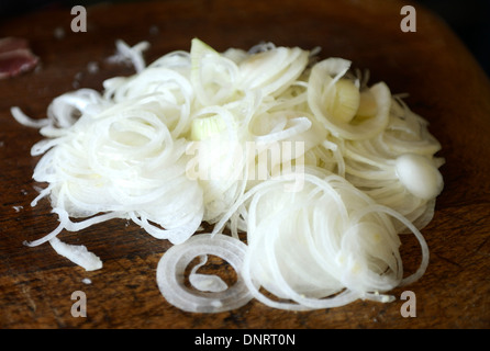 Oignons hachés sur une table de cuisine en bois Banque D'Images