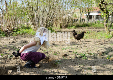 Une fillette de 8 ans jouer avec ses poulets sur un petits Banque D'Images