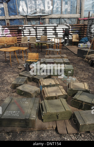 Le Sunny View green caisses de munitions, des tables et des chaises sur le sol, mur de clôture graffiti avant, marché aux puces de Mauerpark, Berlin Banque D'Images