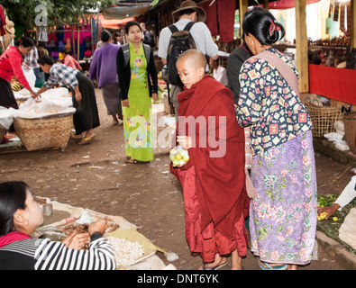 Vendeur dans le marché hebdomadaire village vend certains produits de confiserie de moine novice le 3 novembre 2013 à Ywar Ma, Myanmar. Banque D'Images