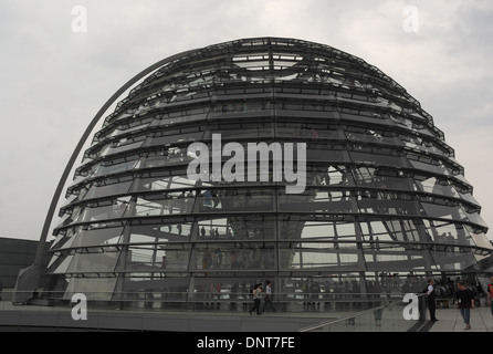 Ciel gris voir les gens marcher autour et à l'intérieur de la grande coupole en verre sur le toit du bâtiment du Reichstag, Berlin, Allemagne Banque D'Images