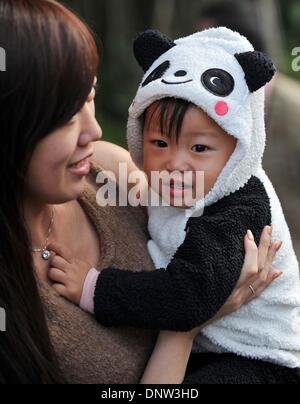 Taipei, Taiwan de la Chine. 6 janvier, 2014. Une mère et son bébé portant costume en forme de panda attendre de voir grand panda cub Yuan Zai au Zoo de Taipei à Taipei, Taiwan, du sud-est de la Chine le 6 janvier 2014. C'était Yuan Zai's première apparition publique. La cub, né le 6 juillet 2013, est le premier bébé de 'Tuan Tuan et Yuan Yuan', qui ont été donnés comme un cadeau de bonne volonté à Taiwan par la partie continentale de Chine. Crédit : Chen Yehua/Xinhua/Alamy Live News Banque D'Images