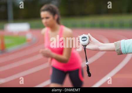 Main d'une femme de distribution exécuter sur la piste de course Banque D'Images