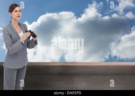 Composite image of businesswoman with binoculars Banque D'Images