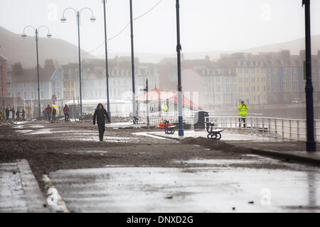 Aberystwyth, Pays de Galles, Royaume-Uni. 6 janvier, 2014. La scène à la suite de la matinée la marée haute à Aberystwyth. L'emblématique abri public s'abaisse sur la plage comme un énorme trou est creusé par les vagues. Les débris sont éparpillés le long de la route et les trottoirs. La station balnéaire d'Aberystwyth, encore ébranlé par d'importants dommages causés par des vagues énormes sur plusieurs jours, a été à nouveau battues à marée haute, le 6 janvier. Des rafales de 70 km/h et une houle énorme causé à des vagues se briser sur les défenses de la mer, les résidents d'immeubles du front de mer d'être évacuées, et la promenade d'être bouclé par la police. Credit : atgof.co/Alamy Live News Banque D'Images