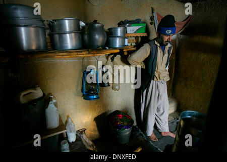 Dec 11, 2005 ; Kobul, Afghanistan ; sans aucune alimentation électrique AC ABDUL QAYOOM, 37, se trouve dans sa maison de brique de boue dans une région où le gouvernement a abandonné les bâtiments sont maintenant les logements des pauvres. QAYOOM prend en charge sa famille en faisant de petits meubles et pelle à neige outils qui lui vaut environ 50 AFG (environ 1 dollar US) par jour et la famille dans la nuit des lanternes utilise pour fournir une Banque D'Images