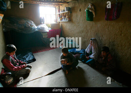 Dec 11, 2005 ; Kobul, Afghanistan ; sans aucune alimentation électrique AC ABDUL QAYOOM, 37, se trouve dans sa maison de brique de boue, où il vit avec sa femme et ses 6 enfants vivent, dans une région où le gouvernement a abandonné les bâtiments sont maintenant les logements des pauvres. QAYOOM prend en charge sa famille en faisant de petits meubles et pelle à neige outils qui lui vaut environ 50 AFG (environ 1 dollar US) par jour Banque D'Images