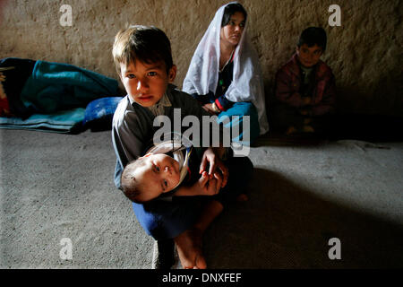 Dec 11, 2005 ; Kobul, Afghanistan ; sans aucune alimentation électrique AC ABDUL QAYOOM, 37, se trouve dans sa maison de brique de boue, où il vit avec sa femme et ses 6 enfants vivent, dans une région où le gouvernement a abandonné les bâtiments sont maintenant les logements des pauvres. QAYOOM prend en charge sa famille en faisant de petits meubles et pelle à neige outils qui lui vaut environ 50 AFG (environ 1 dollar US) par jour. Banque D'Images