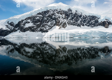 PORT DE NEKO, Antarctique—les montagnes glacées et rocheuses couvertes de glace et de neige à Neko Harbour sur la péninsule Antarctique se reflètent sur des eaux calmes miroiteuses. Banque D'Images