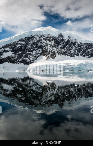 PORT DE NEKO, Antarctique—les montagnes glacées et rocheuses couvertes de glace et de neige à Neko Harbour sur la péninsule Antarctique se reflètent sur des eaux calmes miroiteuses. Banque D'Images